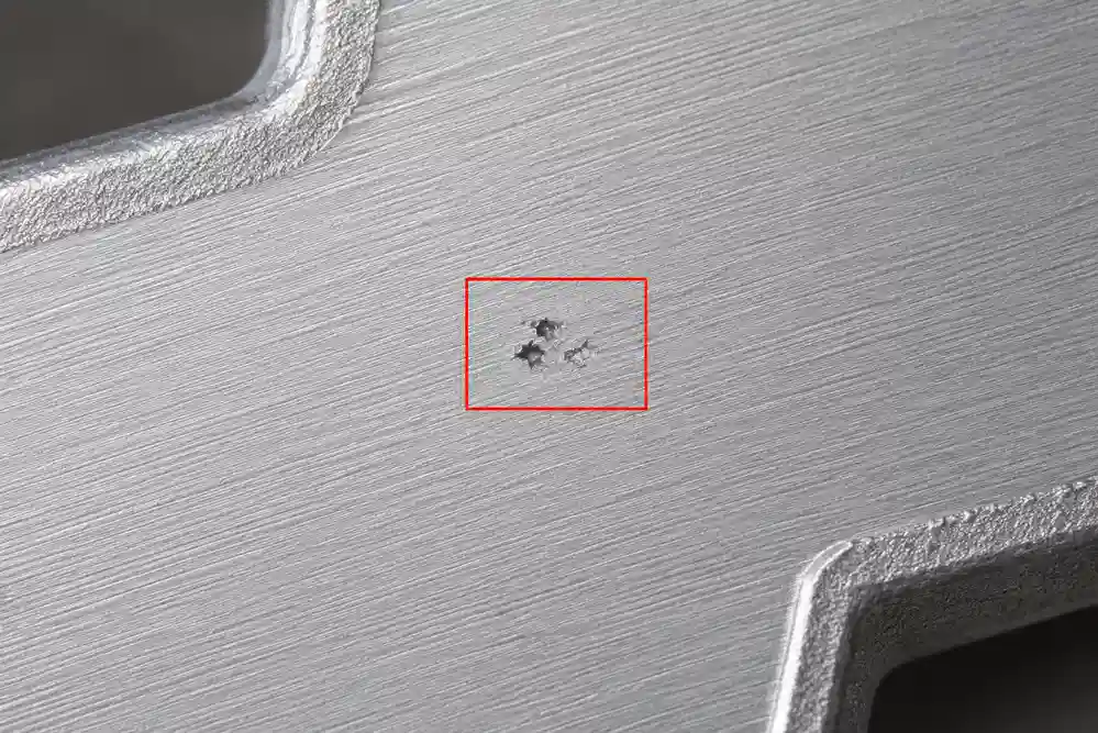 Shrinkage porosity exposed on machined aluminum casting surface