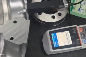 A surface roughness tester checking a machined metal surface.