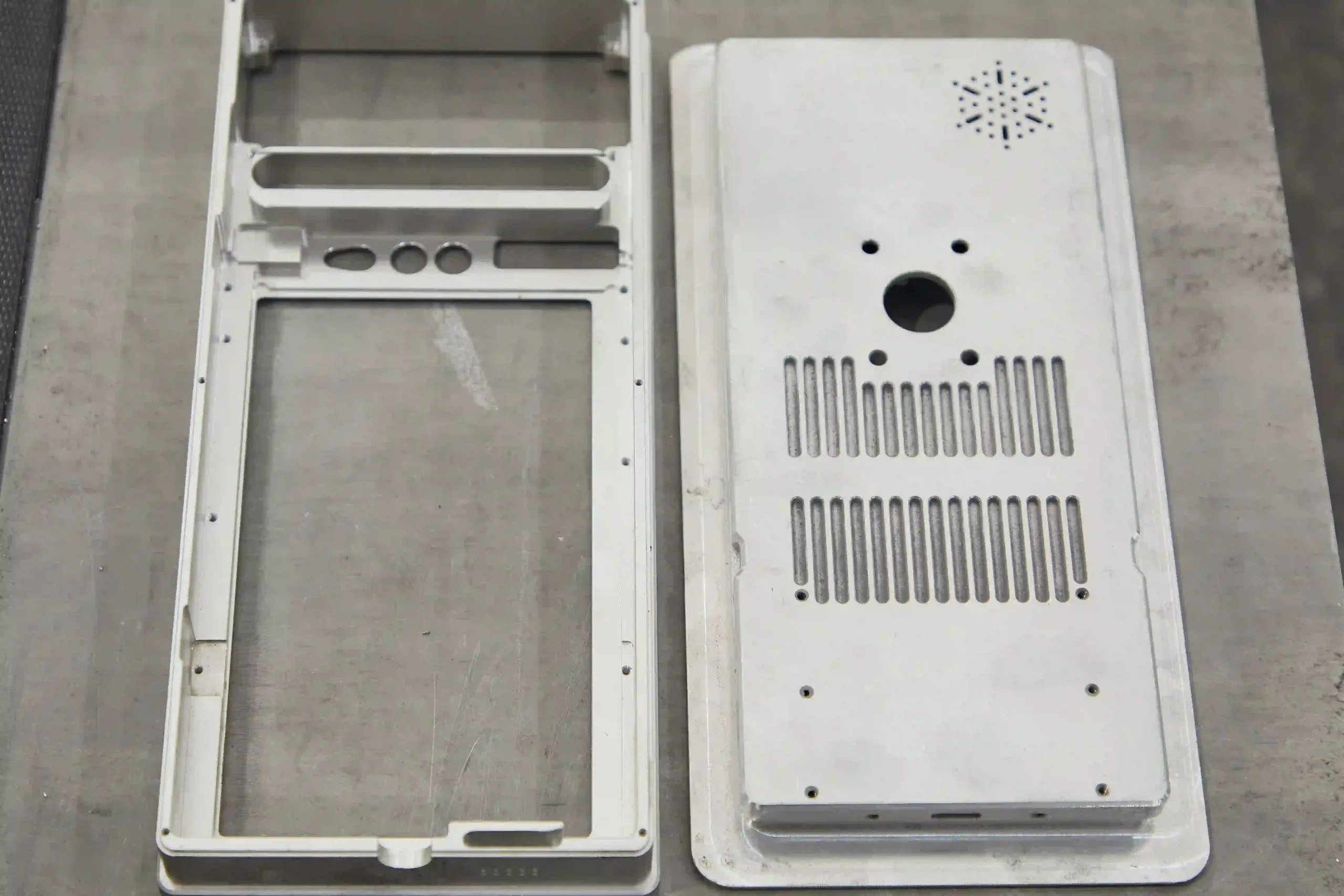 Magnesium electronic housing with ventilation openings and integrated mounting features.